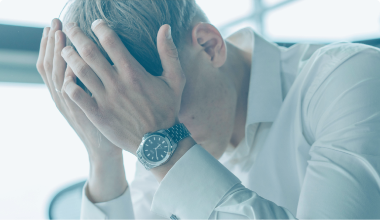 hombre con las manos en la cabeza ya que sufre de estrés postraumático debido a un accidente de tráfico